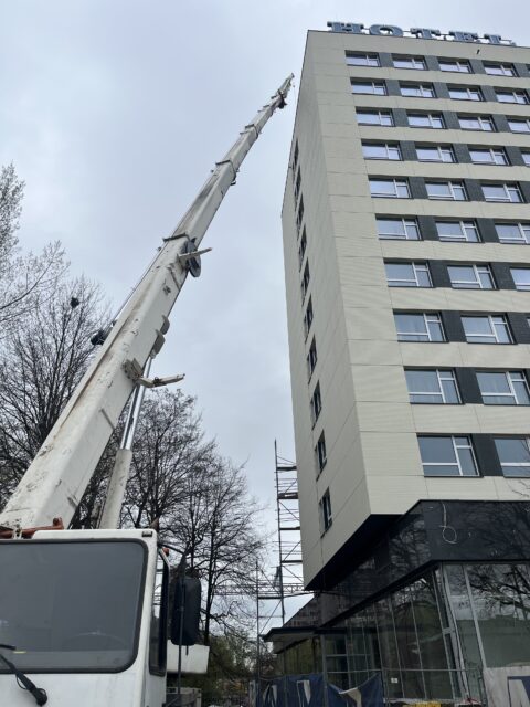 Dźwig na pojeździe podający reklamę na dach
